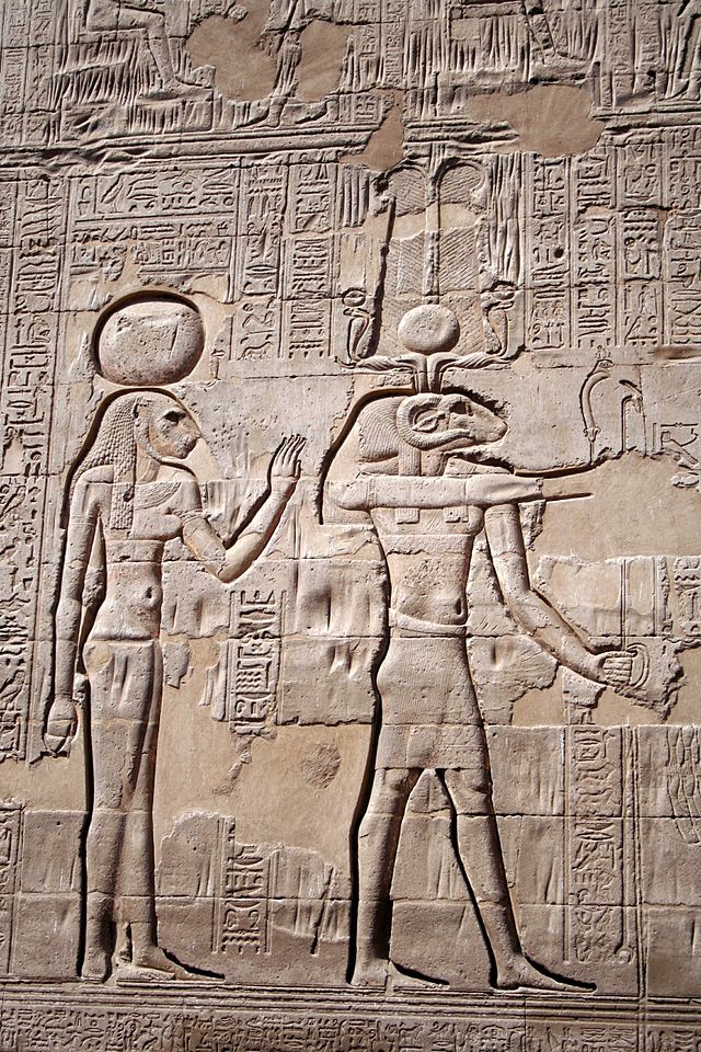 Relevo mostrando Cnum (em sua associação com Rá e Amon) e Neith, com cabeça de leoa, em seu templo em Esna.